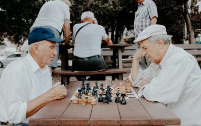 two old men in caps playing chess outside