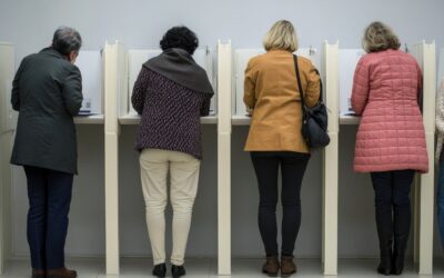 four women stand at polling booths with backs to the camera