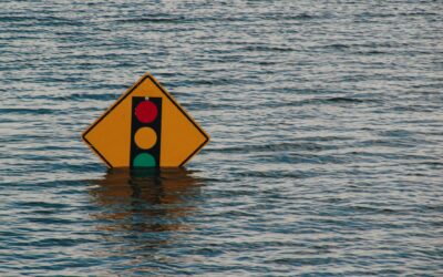 a sign indicating stoplight ahead halfway under water